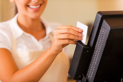 הקופאית מחלפת כרטיס אשראי דרך קופה ממוחשבת לניהול חשבונות